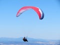 Paraglider flying in the blue sky in Piedrahita, Spain.