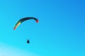 Paraglider flying on colorful parachute in blue clear sky at a bright sunny summer day. Active lifestyle, extreme sport. Freedom c