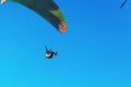 Paraglider flying on colorful parachute in blue clear sky at a bright sunny summer day. Active lifestyle, extreme sport. Freedom c