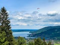 Paraglider flying over lake. Paragliding under Bavarien landscape