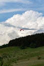 Paraglider flying over mountains in summer day