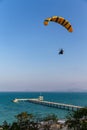 Paraglider flying over the sea coast in blue sky background Royalty Free Stock Photo