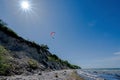 Paraglider is flying over the steep coast on the beach of the Baltic Sea, beautiful landscape for outdoor sports, blue sky with Royalty Free Stock Photo