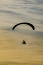 Paraglider flying in the sky at sunset