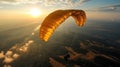 Paraglider flying in the sunset sky in yellow parachute