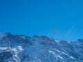 A paraglider in front of a snow covered mountain ridge in Switzerland