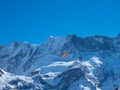 A paraglider in front of a snow covered mountain ridge in Switzerland