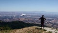 Paraglider launching off mountain top soaring over valley