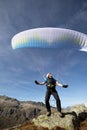 Paraglider pilot stands on a rock and balances his paraglider above his head near Lake Grimsel in the Swiss Alps Royalty Free Stock Photo