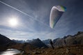 Paraglider Pilot stands on a slope and balances his paraglider above his head in the Alps of Switzerland Royalty Free Stock Photo