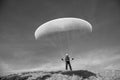 Paraglider Pilot stands on a slope and balances his paraglider above his head in the Alps Royalty Free Stock Photo