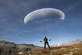 Paraglider Pilot stands on a slope and balances his paraglider above his head in the Alps of Switzerland Royalty Free Stock Photo