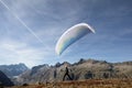 Paraglider Pilot stands on a slope and balances his paraglider above his head in the Alps of Switzerland Royalty Free Stock Photo