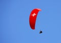 Paraglider with red wing shape on the blue sky in Interlaken, Switzerland.