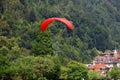 Paraglider with red wing shape in Interlaken, Switzerland.