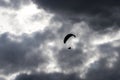 Paraglider silhouette in front of a dark cloudy sky