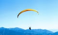 Paraglider soaring in the sky over the blue mountains Royalty Free Stock Photo