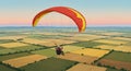 A paraglider soars over a patchwork of agricultural fields, with a person seated in a Royalty Free Stock Photo