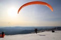 Paraglider is taking off near to mountains. Winter landscape.
