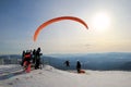 Paraglider is taking off near to mountains. Winter landscape.