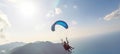 Paraglider tandem flying over the sea with blue water and mountains in bright sunny day. Generative AI Royalty Free Stock Photo