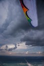 The paraglider under the thunderclouds, the multi-colored wing