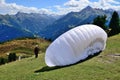 Paraglider with white wing ready for jumping from mountains.