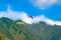 Paragliders fly against the background of mountains in the clouds Royalty Free Stock Photo