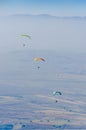 Paragliders flying high above fields