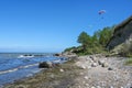 Paragliders are flying over the steep coast on the beach of the Baltic Sea, beautiful landscape for outdoor sports, blue sky with Royalty Free Stock Photo