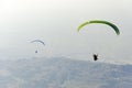 Paragliders silhouette flying over misty mountain