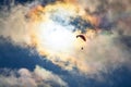 Paragliding adventure sport against bright sun on cloudy sky Royalty Free Stock Photo