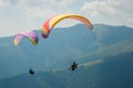 Two paragliders fly over a mountain valley on a sunny summer day. Royalty Free Stock Photo