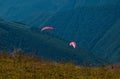 Two paragliders fly over a mountain valley on a sunny summer day. Royalty Free Stock Photo
