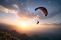 Paragliding flying above dramatic sky at sunset.