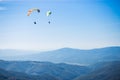 Paragliding group in air sport on top of a mountain. The whole world is in sight.