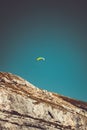 Paragliding over the tyrolean alps with a yellow parachute blue sky and vintage looking mountain picture nature Royalty Free Stock Photo