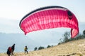 Paragliding pilots checking paraglider wing before take-off Sarangkot Hill Pokhara Nepal