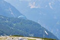 Paraglider flying over the sky with blue water and mountains in bright sunny day. Aerial view of paraglide Royalty Free Stock Photo