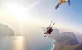 Paragliding in the sky. Paraglider tandem flying over the sea with blue water and mountains in bright sunny day. Generative AI Royalty Free Stock Photo