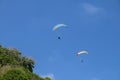 Paragliding in the sky. Two single paragliders flying in bright sunny day over tropical Bali island. Beautiful paraglider on a