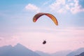 Paragliding in tandem in Interlaken, Switzerland. Photographed in pink sunset light. Silhouettes of paragliders and Swiss Alps.