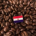 A Paraguay flag placed over roasted coffee beans