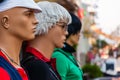 Three mans, mannequins in different clothes standing on first row street sea promenade full of walking tourists, people, souvenirs