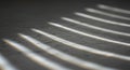 Parallel beams of light create a pattern on a textured gray surface, emphasizing linear Royalty Free Stock Photo