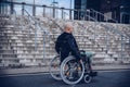 Paralyed man sitting on wheel chairin front of the stairs