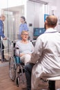 Paralyzed discussing with geriatrician sitting in wheelchair Royalty Free Stock Photo