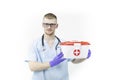 Paramedic in glasses and blue latex gloves holds red cross medical case close up