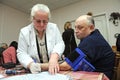 Paramedic taking blood pressure and heart rates by tonometer from a patient