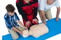 Paramedic training cardiopulmonary resuscitation to senior man and boy Royalty Free Stock Photo